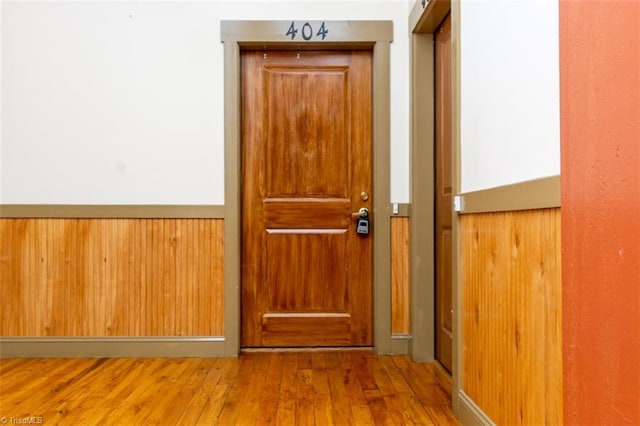 doorway to outside with hardwood / wood-style floors and wood walls