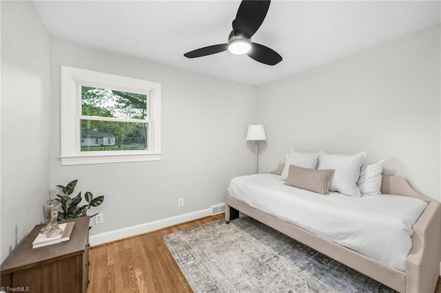 bedroom featuring wood finished floors, baseboards, and a ceiling fan