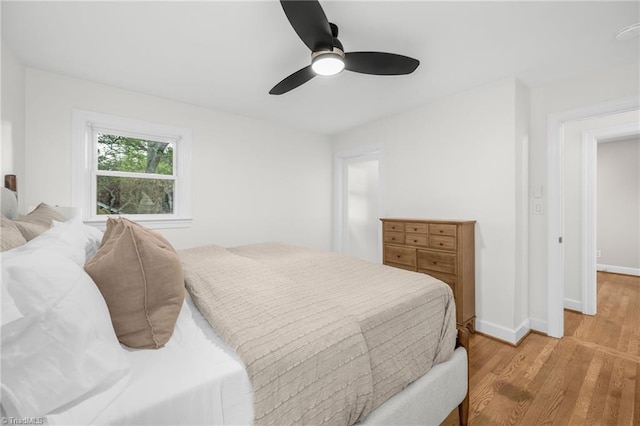 bedroom with light wood-type flooring, baseboards, and ceiling fan