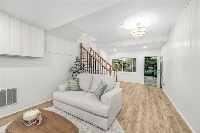 living area featuring light wood-style floors, stairway, and baseboards
