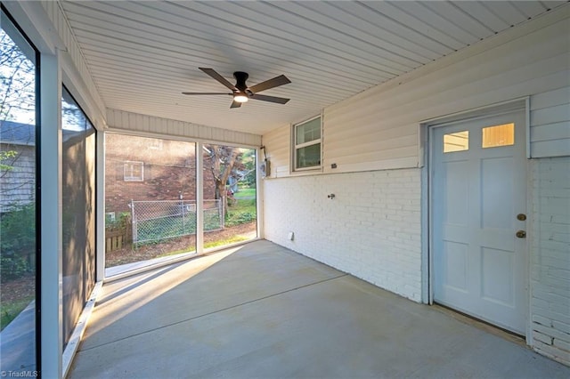 unfurnished sunroom with healthy amount of natural light and ceiling fan