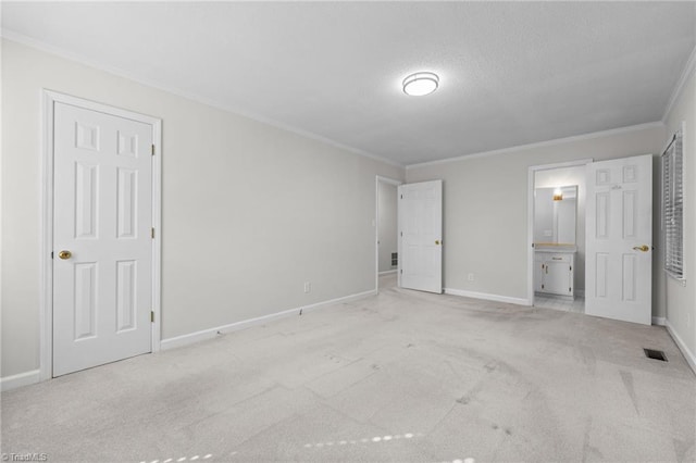 211 Forestview Dr, Elon, NC 27244 - unfurnished bedroom featuring ornamental molding, carpet, connected bathroom, and a textured ceiling