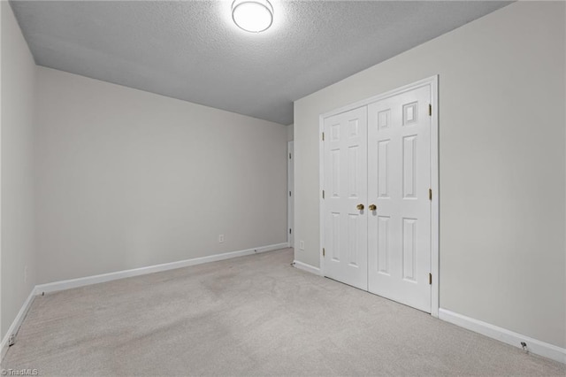 211 Forestview Dr, Elon, NC 27244 - unfurnished bedroom with carpet, a closet, and a textured ceiling