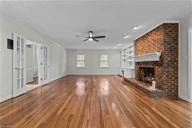 211 Forestview Dr, Elon, NC 27244 - unfurnished living room featuring ornamental molding, a ceiling fan, wood finished floors, french doors, and a brick fireplace