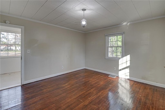 spare room featuring ornamental molding and dark hardwood / wood-style floors