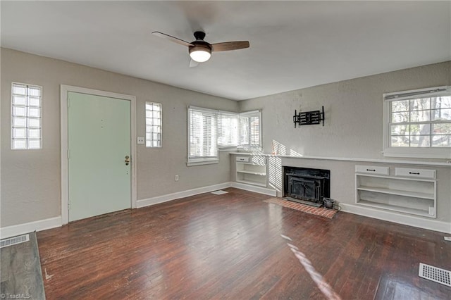 unfurnished living room featuring dark hardwood / wood-style flooring and ceiling fan