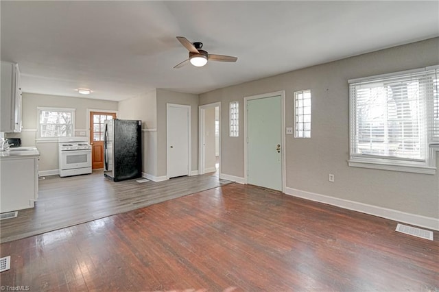 unfurnished living room featuring ceiling fan, sink, and hardwood / wood-style floors