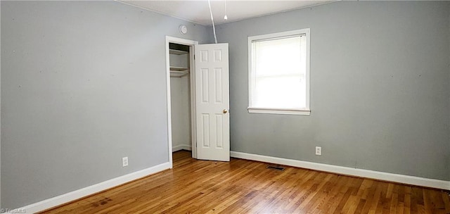 unfurnished bedroom featuring light wood-type flooring and a closet