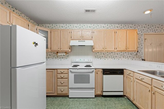 kitchen featuring a textured ceiling, light brown cabinets, white appliances, and sink