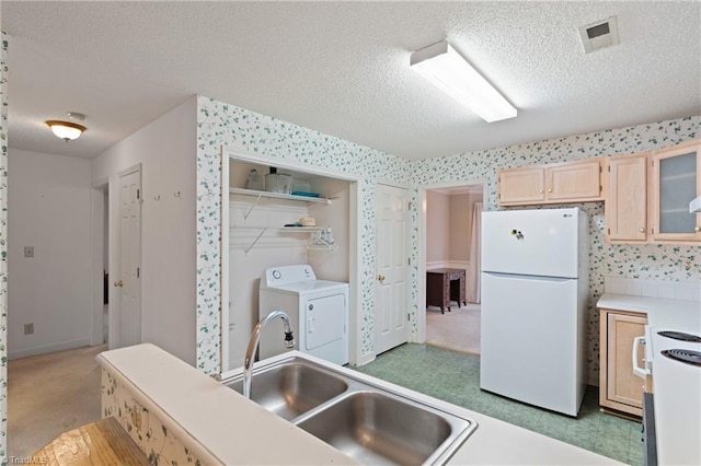 kitchen with washer / dryer, white appliances, a textured ceiling, and light brown cabinetry