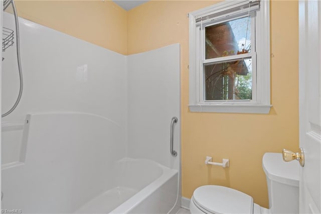 bathroom featuring tub / shower combination and toilet