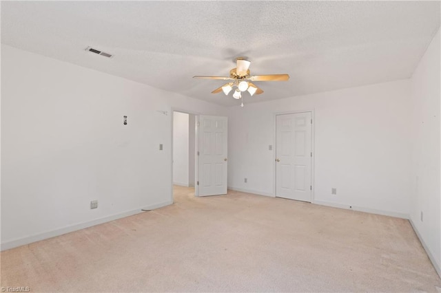 carpeted spare room with ceiling fan and a textured ceiling