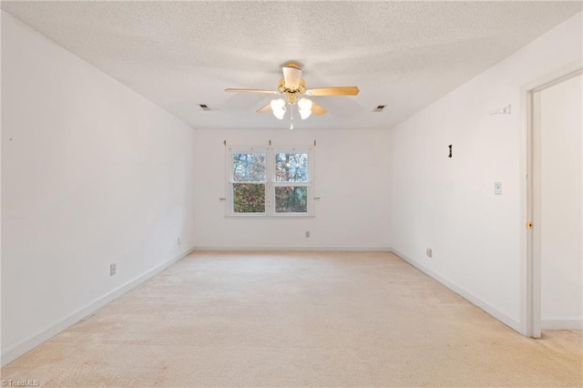 carpeted empty room featuring ceiling fan and a textured ceiling