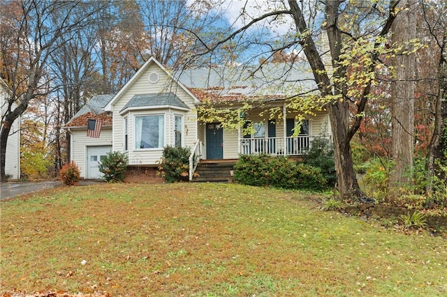 view of front of property with a porch, a garage, and a front lawn