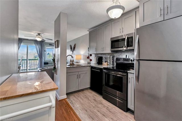 kitchen with ceiling fan, gray cabinets, sink, and stainless steel appliances