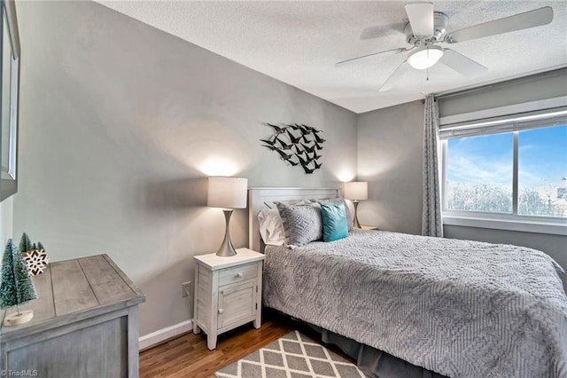 bedroom featuring hardwood / wood-style floors, ceiling fan, and a textured ceiling