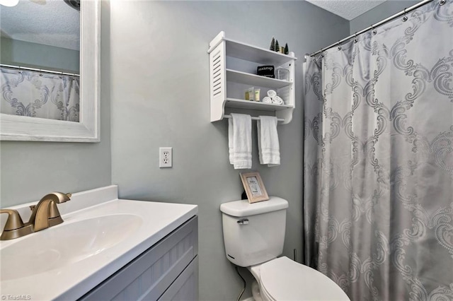 bathroom featuring vanity, a shower with shower curtain, a textured ceiling, and toilet