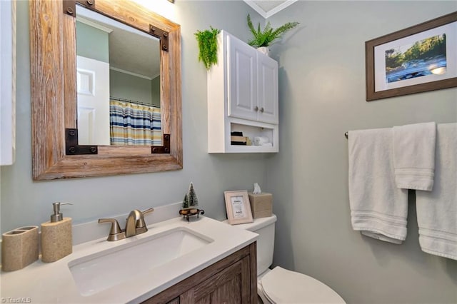 bathroom featuring vanity, toilet, and crown molding