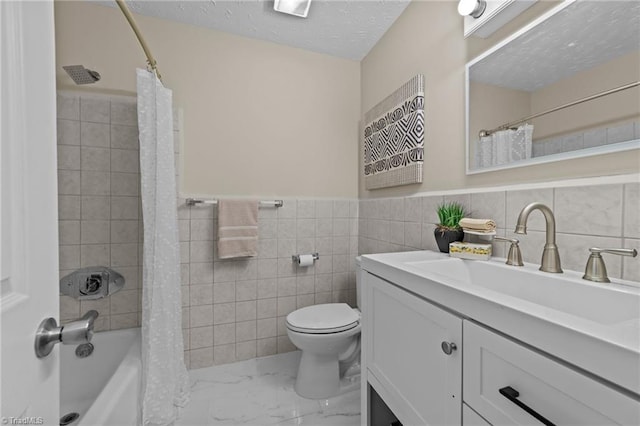 full bathroom with a textured ceiling, vanity, shower / tub combo, and tile walls