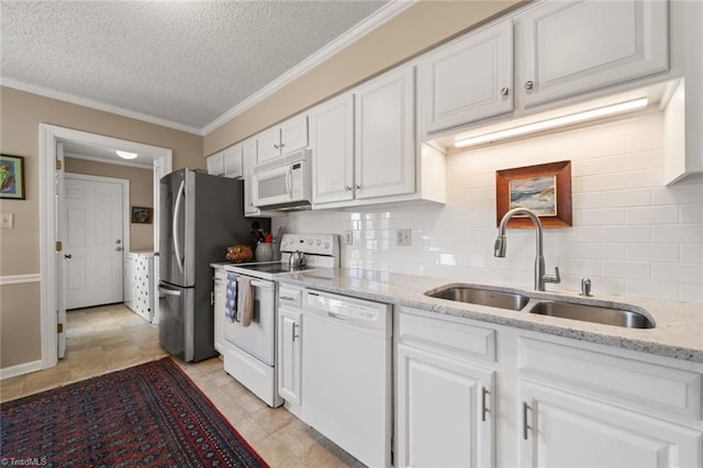 kitchen featuring sink, tasteful backsplash, white appliances, light stone countertops, and white cabinets