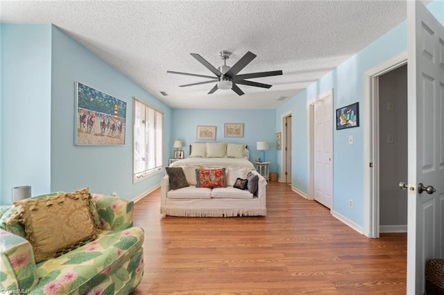 bedroom featuring ceiling fan, a textured ceiling, and light wood-type flooring