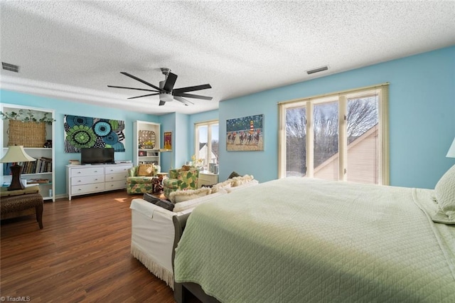 bedroom featuring dark wood-type flooring, access to outside, a textured ceiling, and ceiling fan