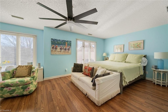 bedroom with multiple windows, dark wood-type flooring, and a textured ceiling