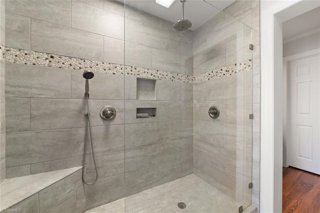 bathroom featuring ornamental molding, tiled shower, and hardwood / wood-style floors