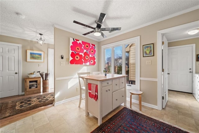 kitchen with a breakfast bar area, a kitchen island, ornamental molding, a textured ceiling, and white cabinets