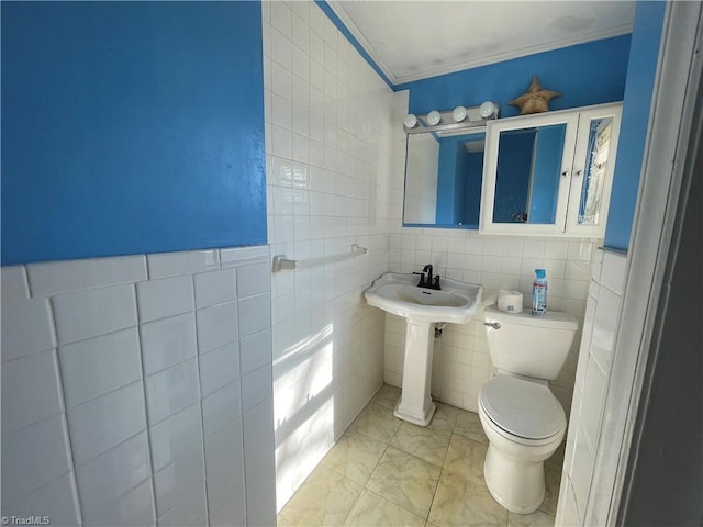 half bathroom with toilet, a sink, and tile walls