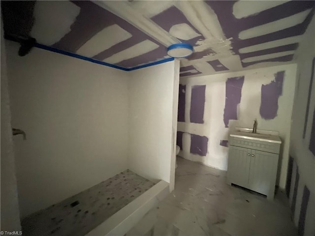 bathroom featuring marble finish floor, a shower stall, and vanity