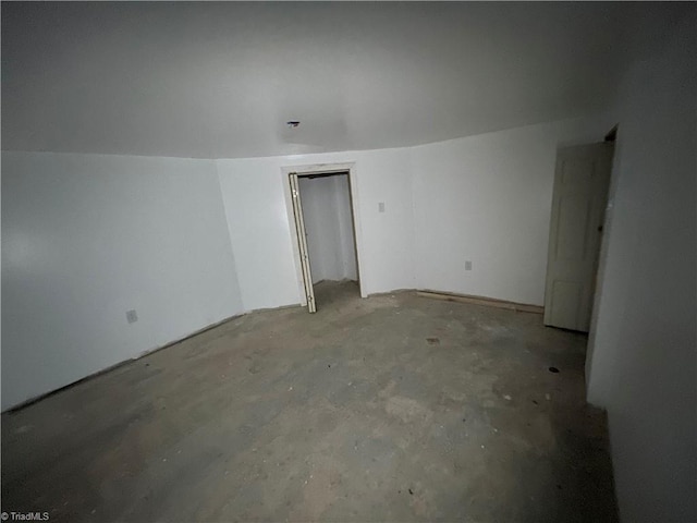 unfurnished room with unfinished concrete flooring