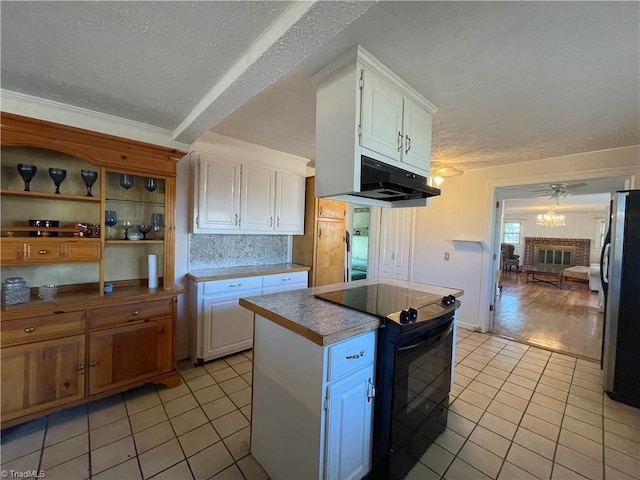 kitchen featuring white cabinets, under cabinet range hood, black appliances, and light tile patterned floors