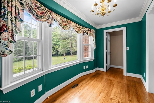 12088 Burlington Rd, Hurdle Mills, NC 27541 - unfurnished dining area featuring a chandelier, plenty of natural light, baseboards, light wood-style flooring, and crown molding