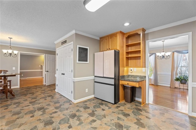 kitchen featuring an inviting chandelier, stone finish floor, and ornamental molding