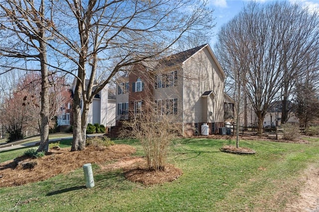 view of side of property with central air condition unit and a lawn