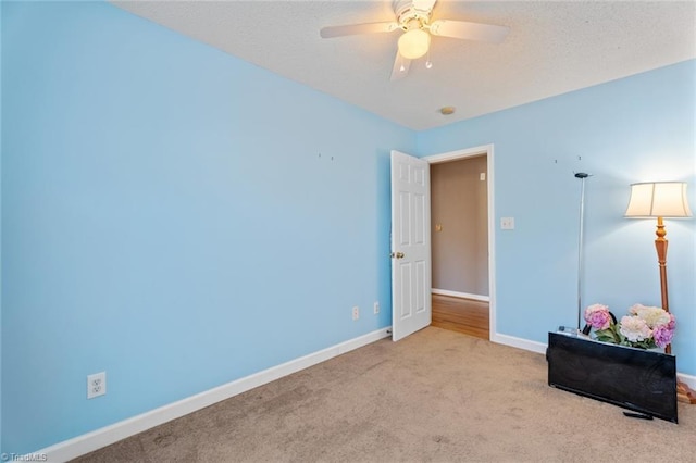 interior space with ceiling fan, a textured ceiling, and baseboards