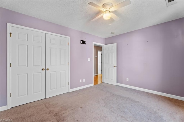 unfurnished bedroom featuring carpet, baseboards, visible vents, a closet, and a textured ceiling