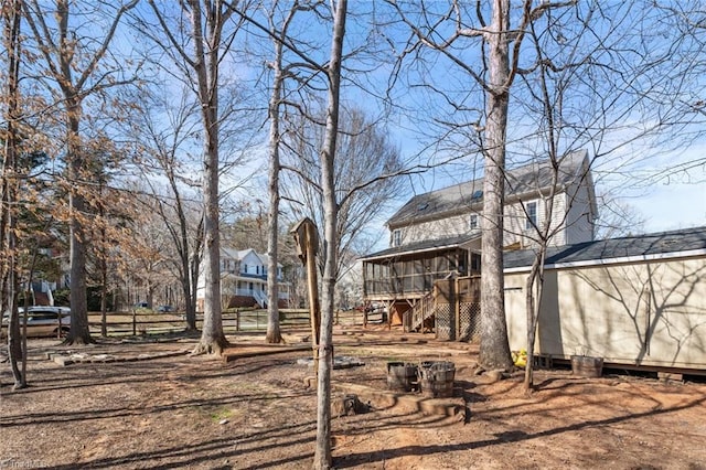 view of yard with an outdoor structure, stairway, and a sunroom