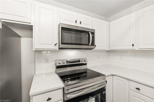 kitchen with backsplash, appliances with stainless steel finishes, a textured ceiling, and white cabinets