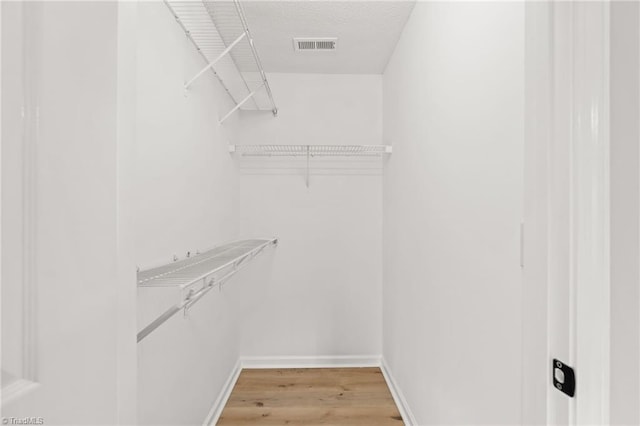 spacious closet featuring hardwood / wood-style floors