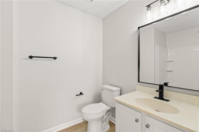 bathroom with vanity, toilet, and wood-type flooring