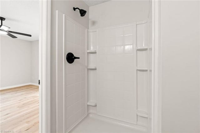 bathroom featuring ceiling fan, hardwood / wood-style flooring, and tiled shower