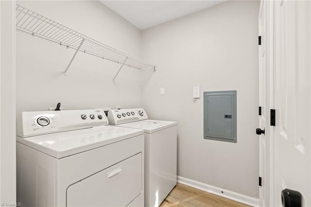 washroom with separate washer and dryer, light hardwood / wood-style flooring, and electric panel