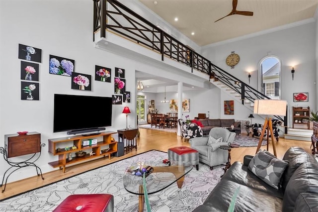 living room with stairway, crown molding, and wood finished floors