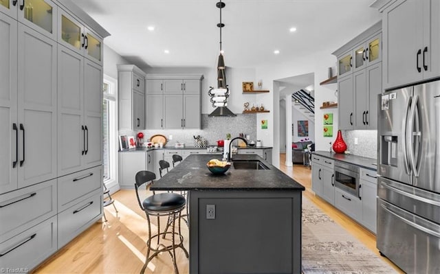 kitchen with range hood, open shelves, tasteful backsplash, a sink, and stainless steel appliances