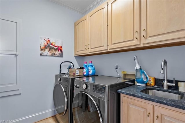 laundry room with cabinet space, ornamental molding, washing machine and dryer, and a sink