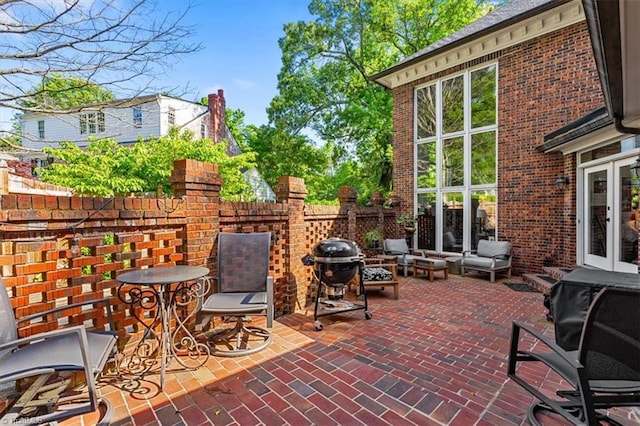 view of patio with fence, french doors, and a grill