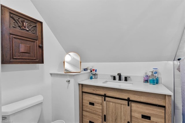 bathroom with vanity, vaulted ceiling, and toilet