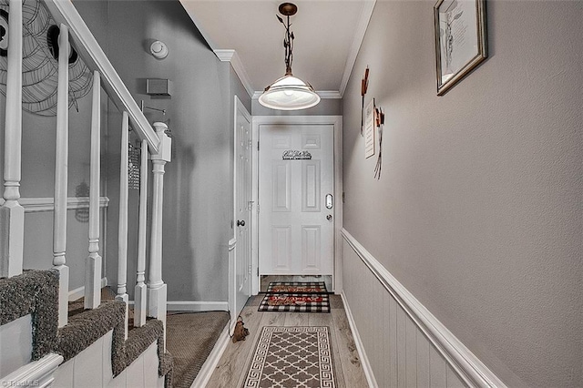 doorway to outside featuring hardwood / wood-style floors and crown molding